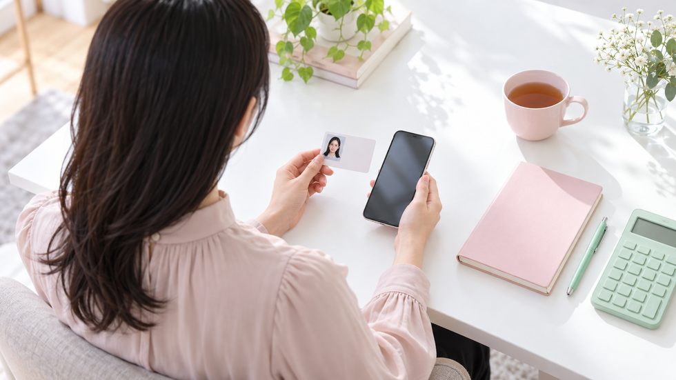 面接に持っていく顔写真付き身分証とスマホを手にした女性