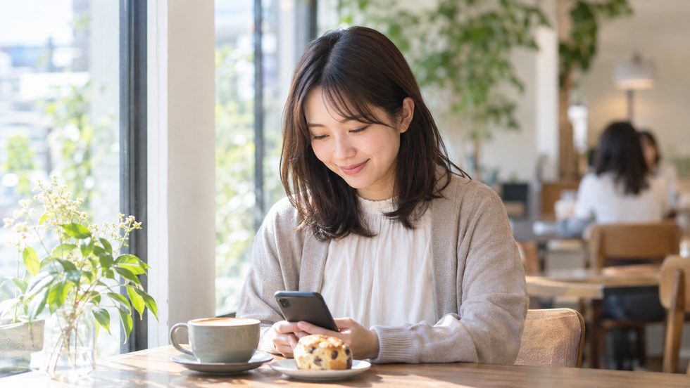 空き時間にスマホで仕事を調べる女性のイメージ